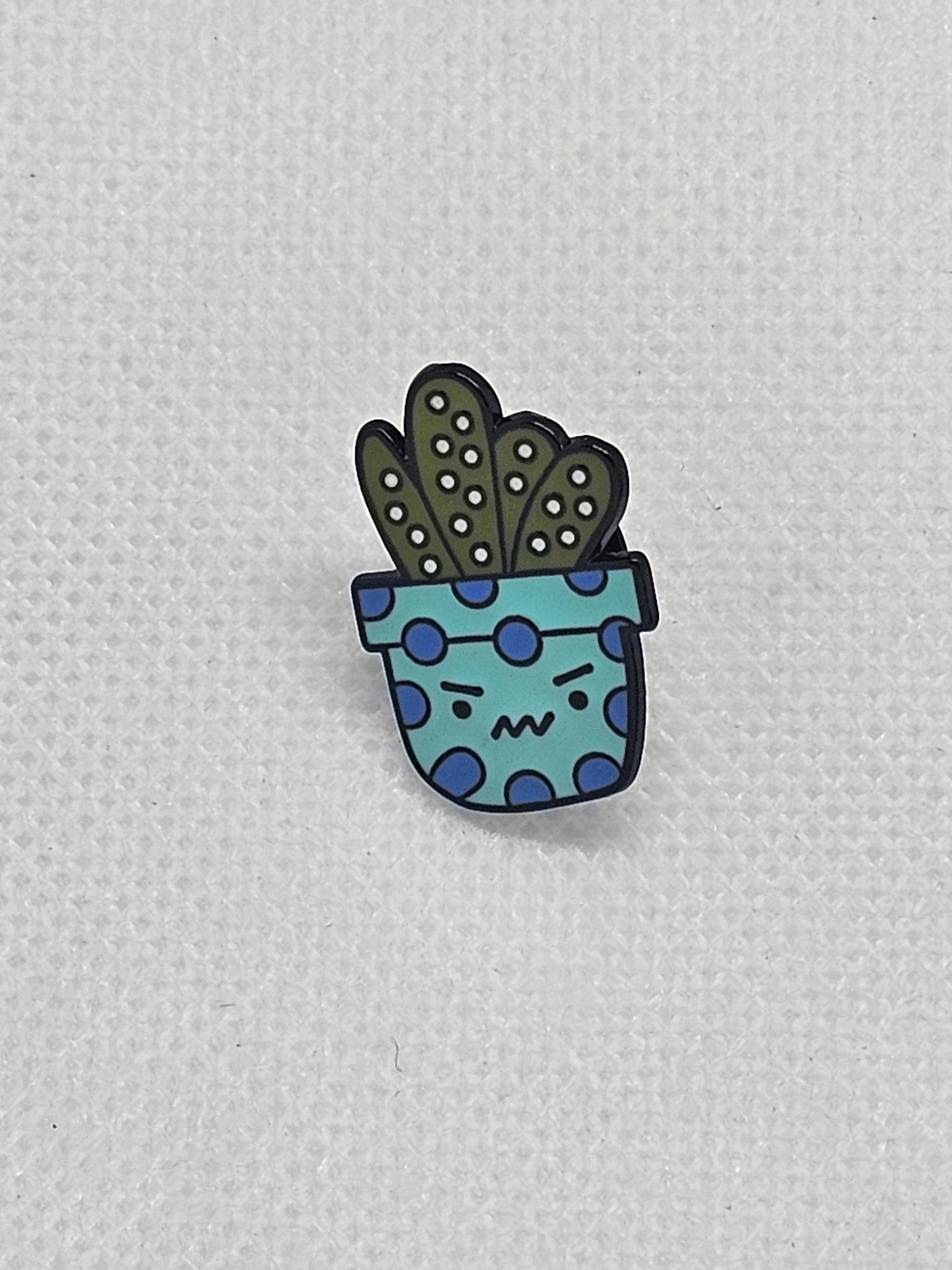 Quirky enamel pin badge featuring an angry cactus in a blue spotted pot, perfect for bags or jackets.