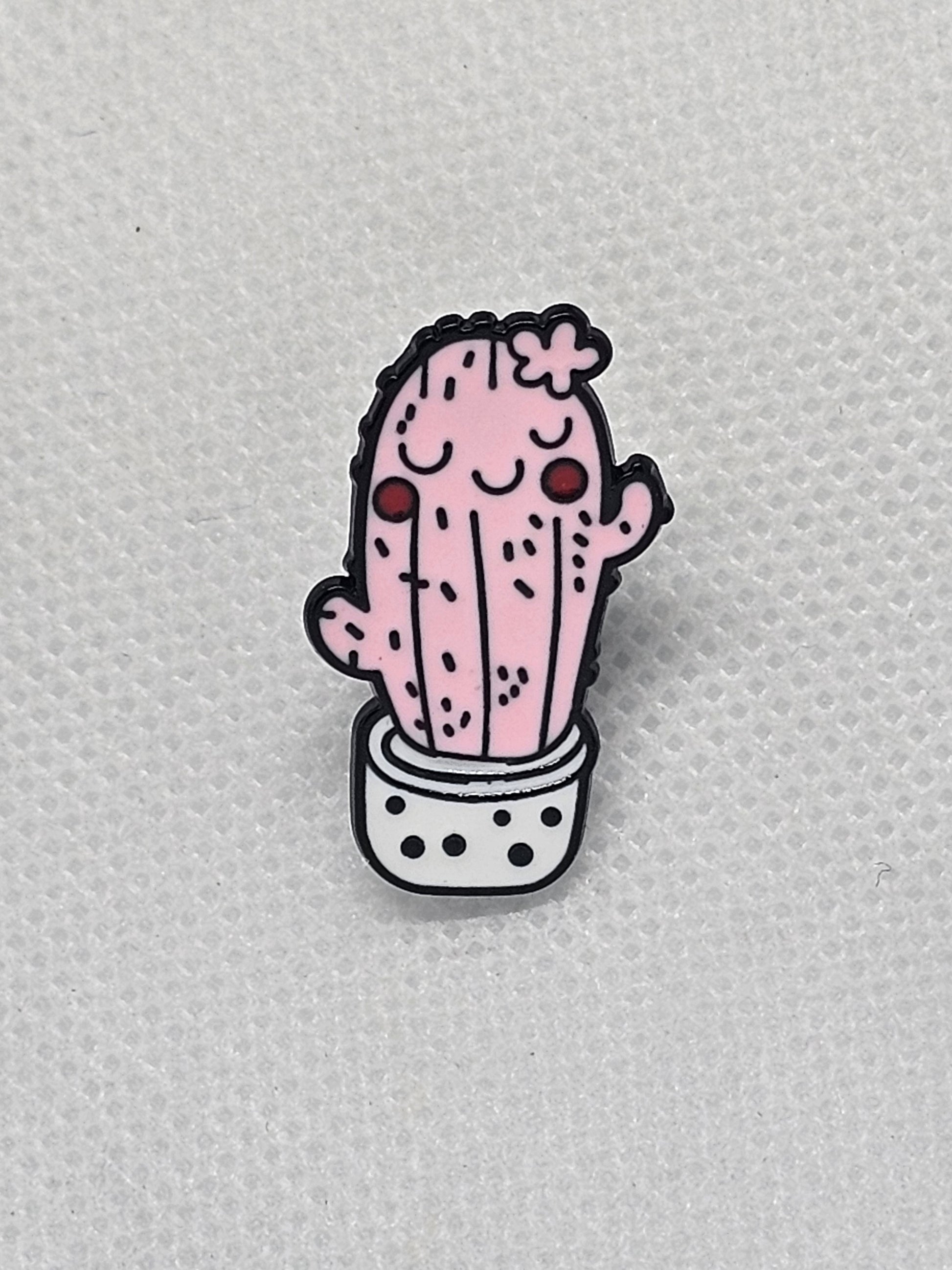 Cute pink cactus pin badge in a pot with a smiling face, perfect for backpacks and jackets.