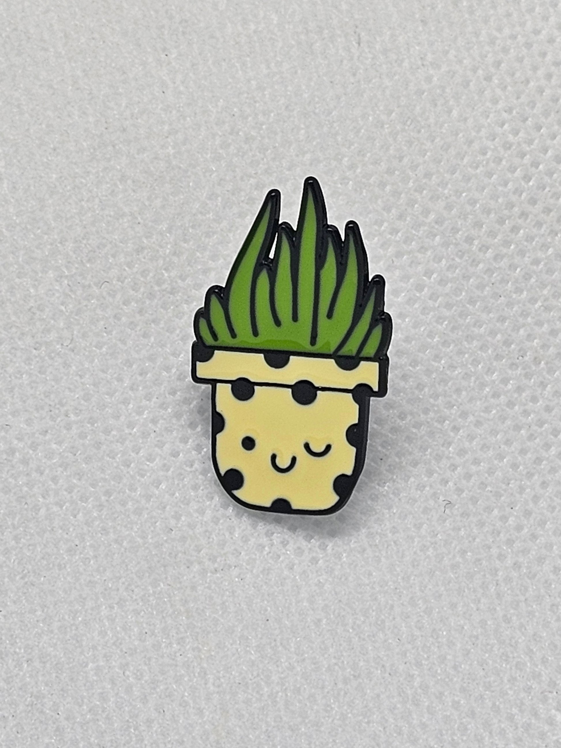 Cute engraved enamel pin badge featuring a smiling plant in a decorative pot with polka dots.