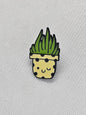 Cute engraved enamel pin badge featuring a smiling plant in a decorative pot with polka dots.