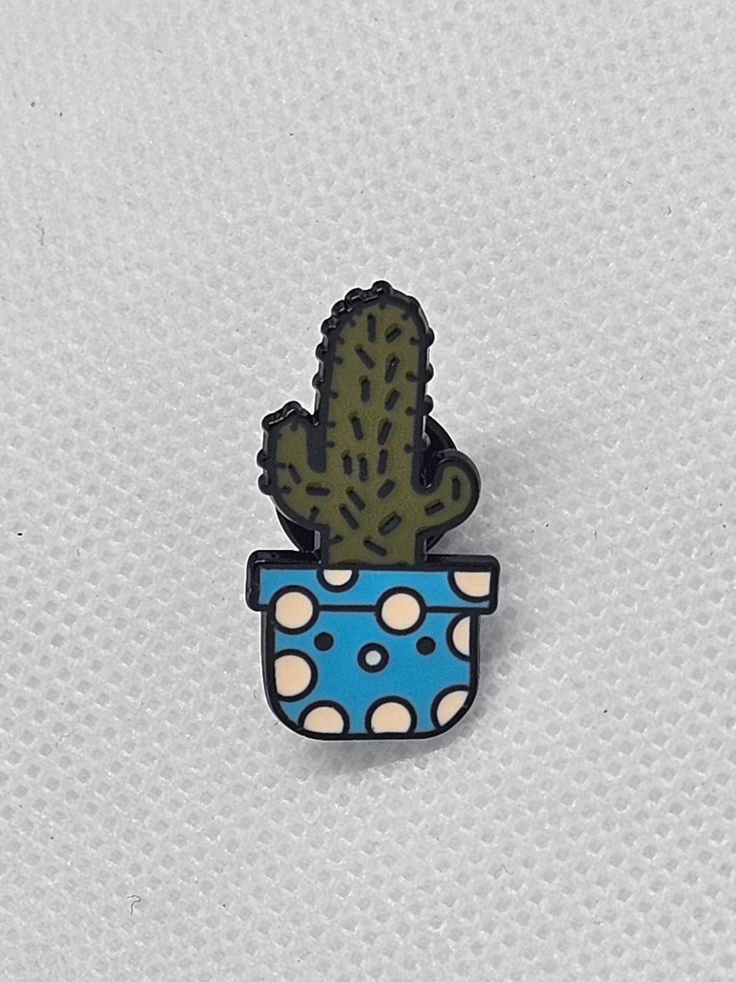 Cactus pin badge in a blue pot with white polka dots, perfect for backpacks or jackets.