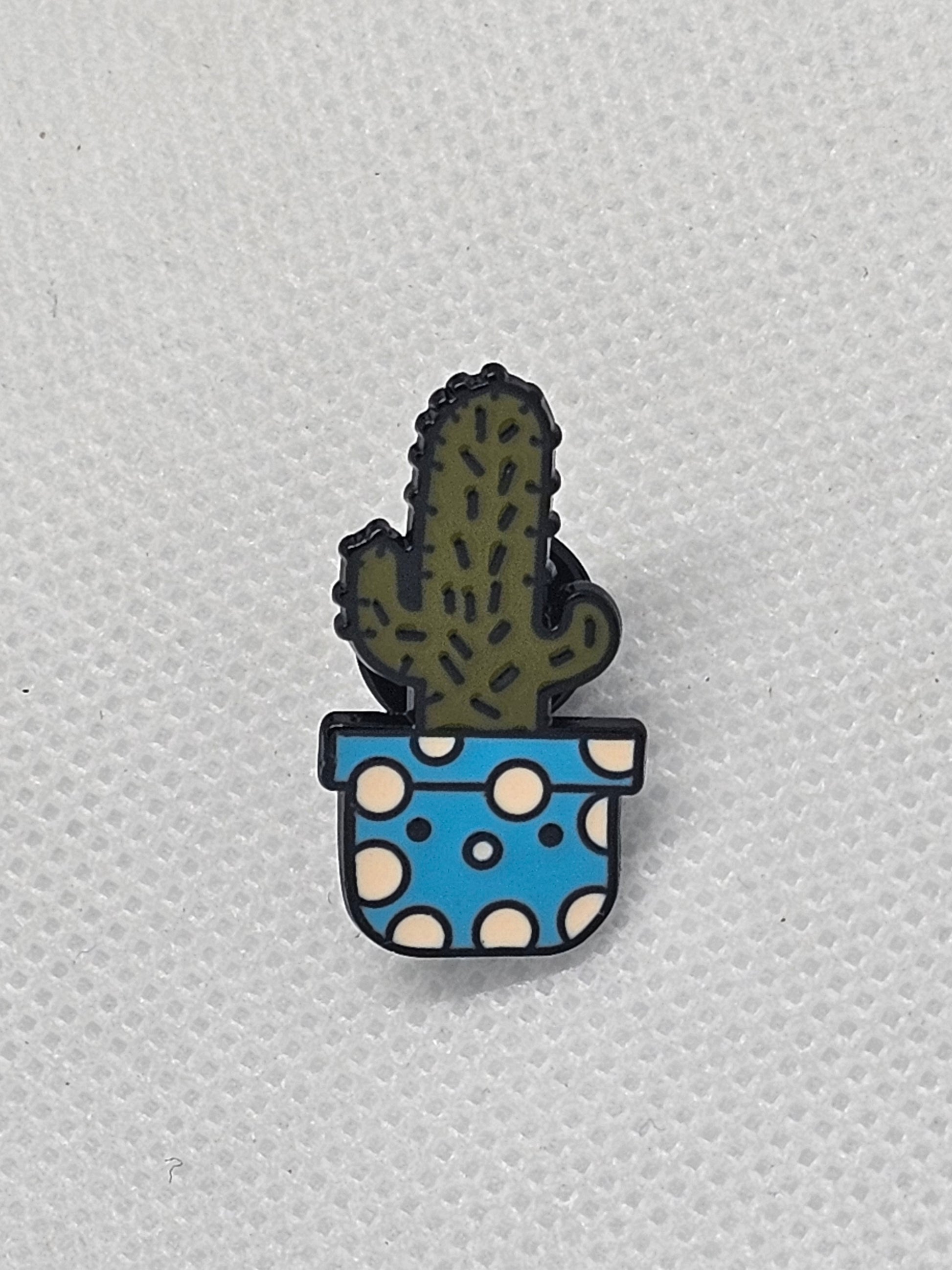 Cactus pin badge in a blue pot with white polka dots, perfect for backpacks or jackets.