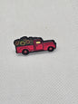 Red enamel pin badge of a vintage truck carrying colorful flowers, perfect for plant lovers.