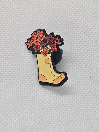Enamel pin badge featuring a yellow boot filled with colorful flowers, perfect for plant lovers.