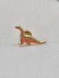 Cute dinosaur enamel pin badge in orange and gold, perfect for bags or clothing accessories.