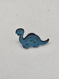 Cute blue herbivore dinosaur pin badge, perfect accessory for bags or clothing, ideal for dinosaur lovers.