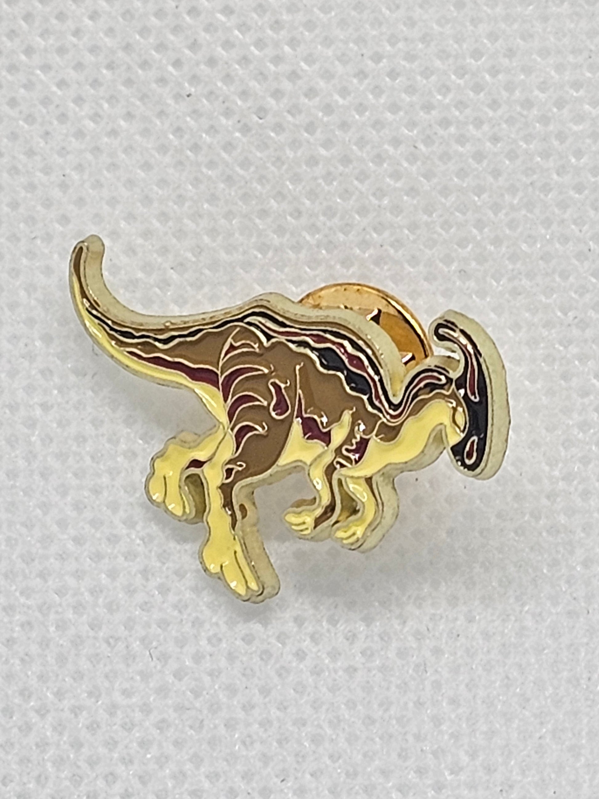 Gold dinosaur enamel pin badge, perfect accessory for dinosaur lovers, ideal for bags or clothing.