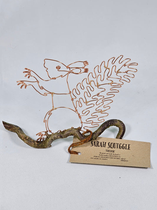 Decorative wall art with wire sculpture of a Squirrel, attached to a white background with a tag.