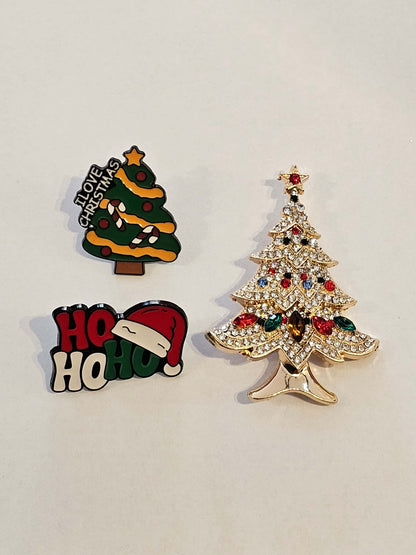 Three Christmas-themed pins on a light gray background
