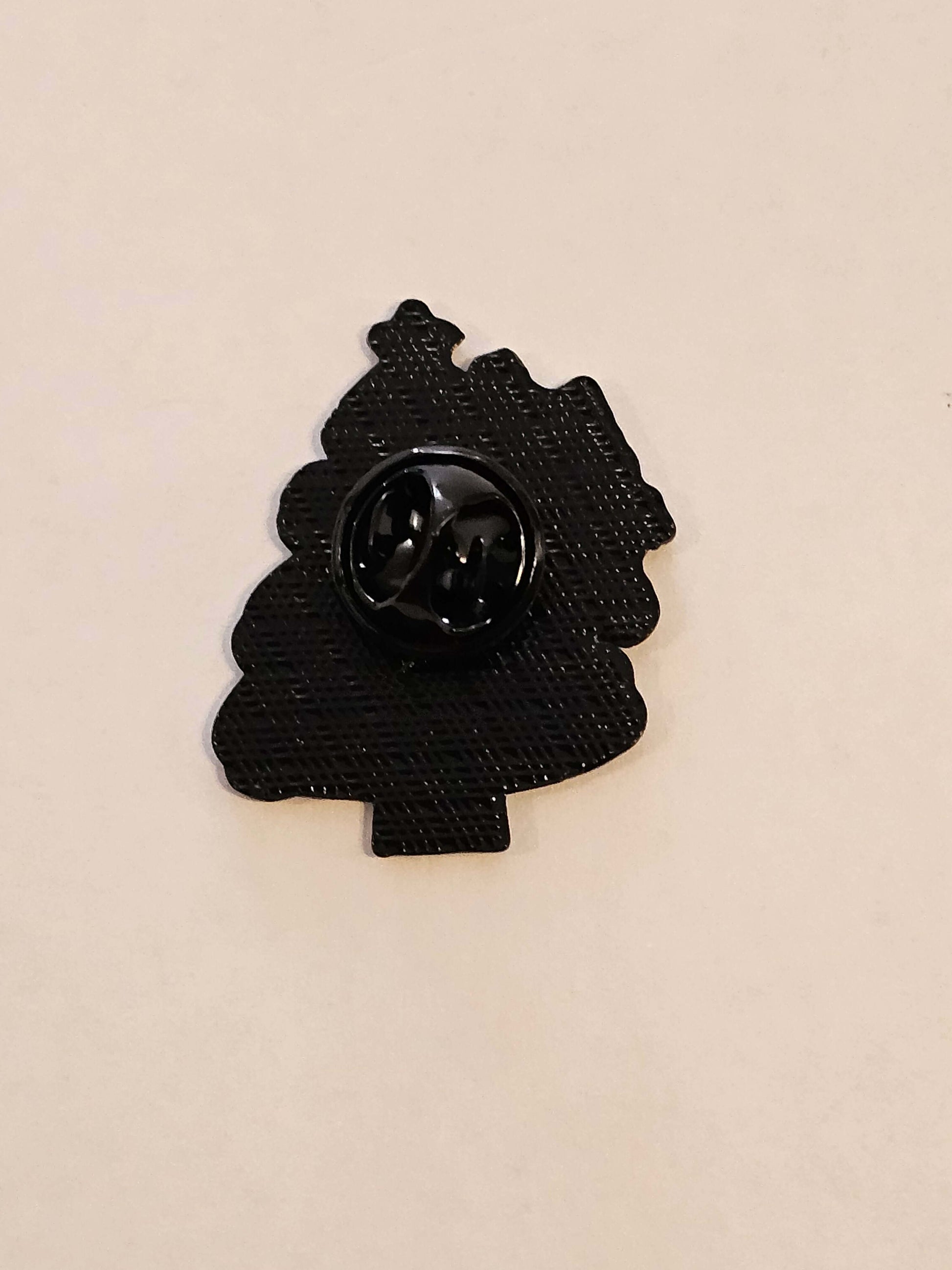 Black decorative pin on a beige background
