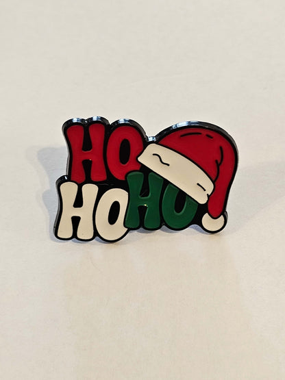 Christmas-themed badge with Santa hat and 'HO HO HO' text on a beige background