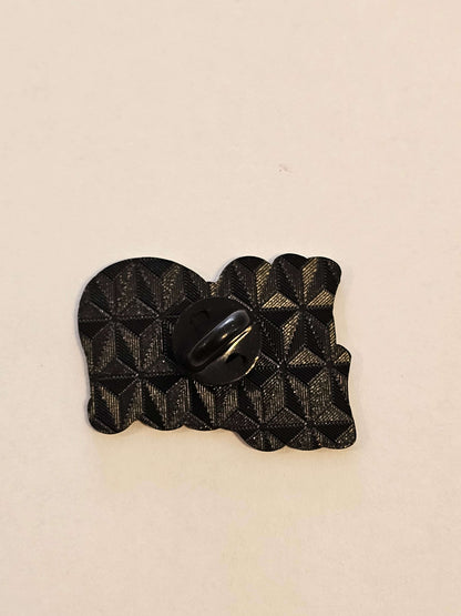 Black textured pin  on a beige background