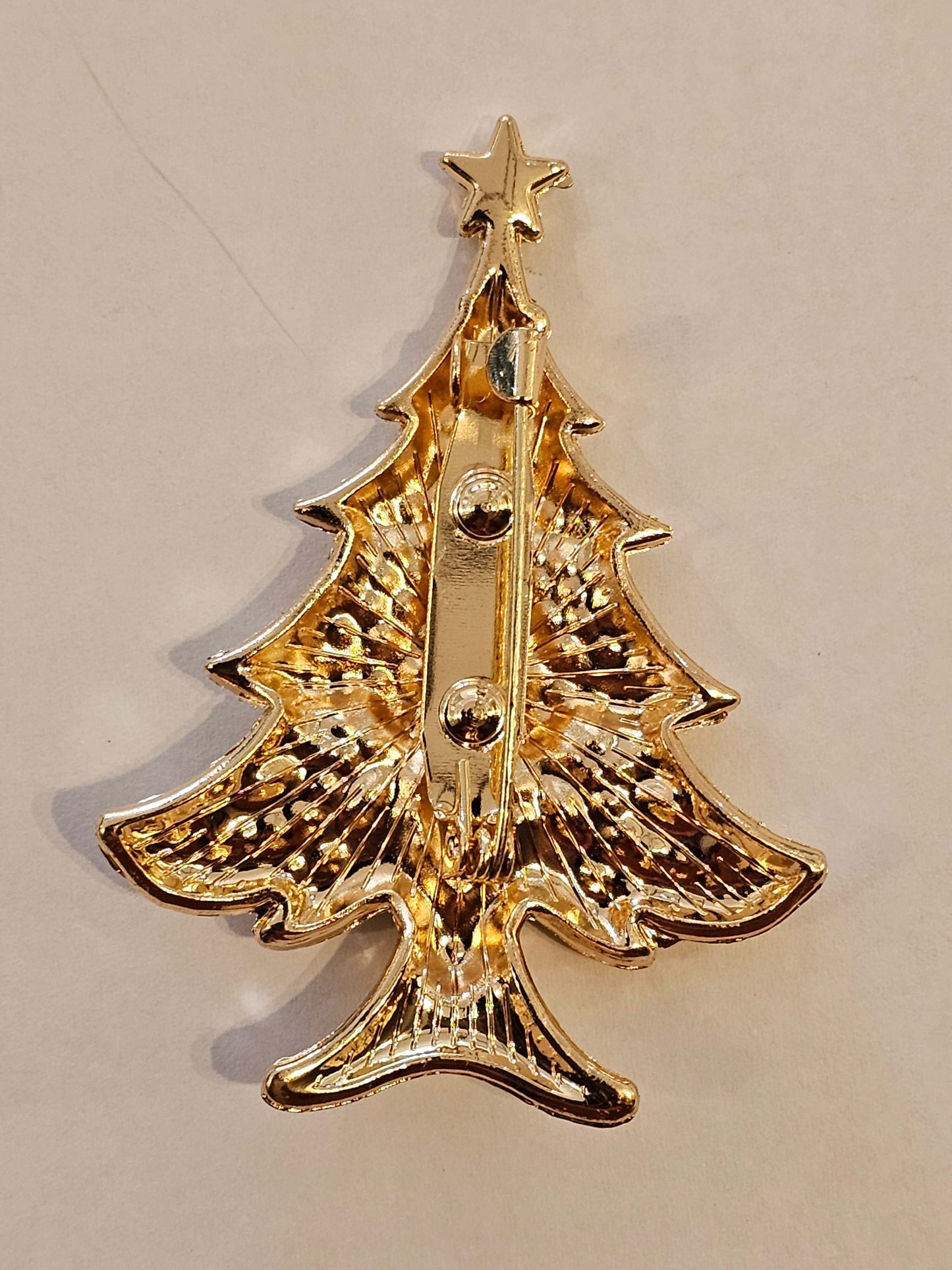 Decorative gold coloured pin on a beige background