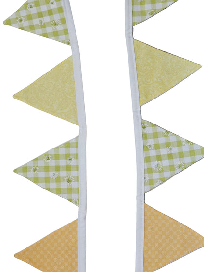 Fabric triangle banner with green and yellow checkered pattern on a wooden surface