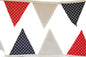Triangular flags with red, white, and blue patterns on a wooden background