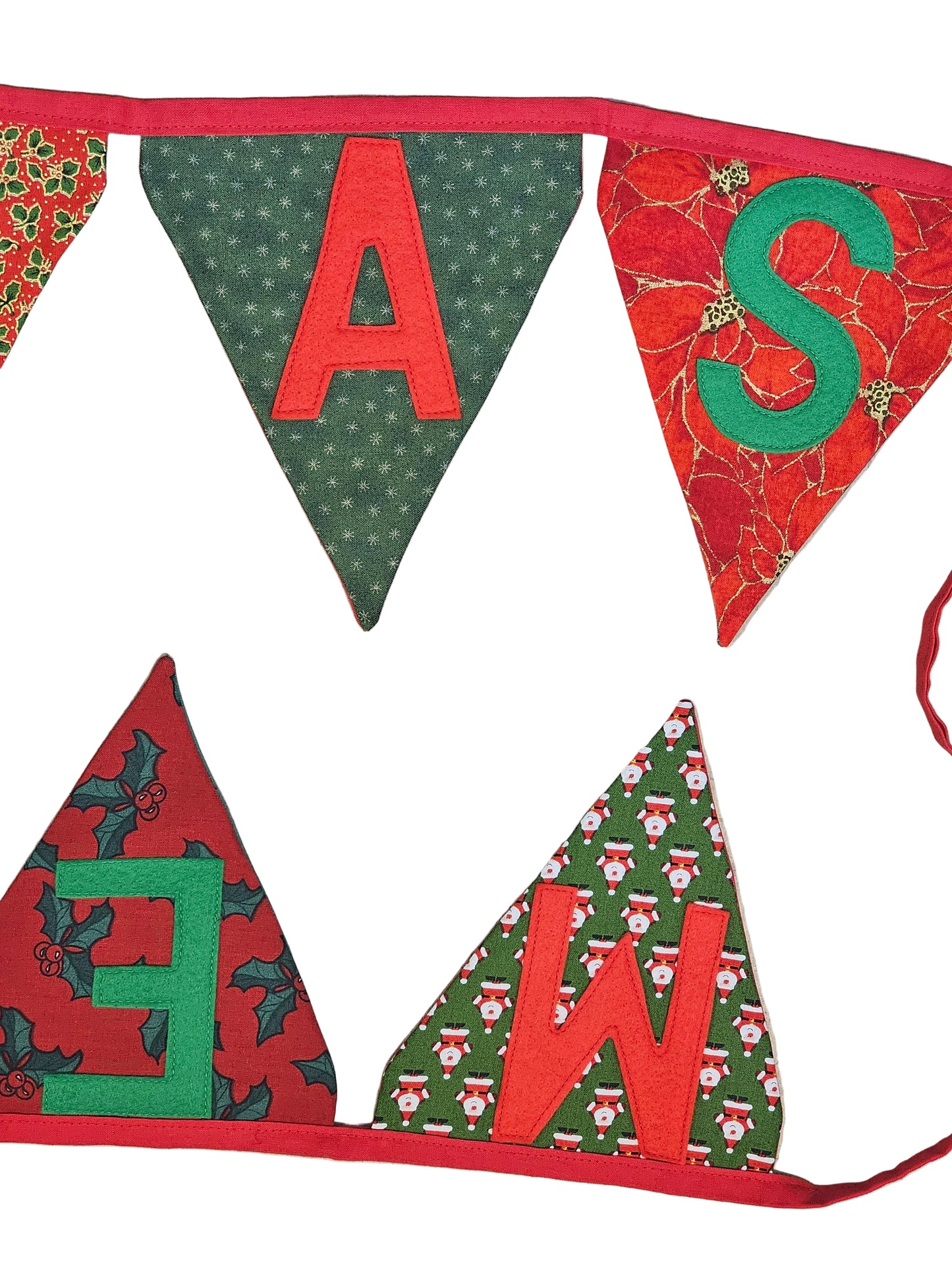 Christmas-themed fabric pennant banner with red, green, and white patterns on a wooden surface.
