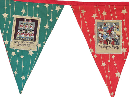 Decorative pennant banner with festive designs and text on a wooden surface.
