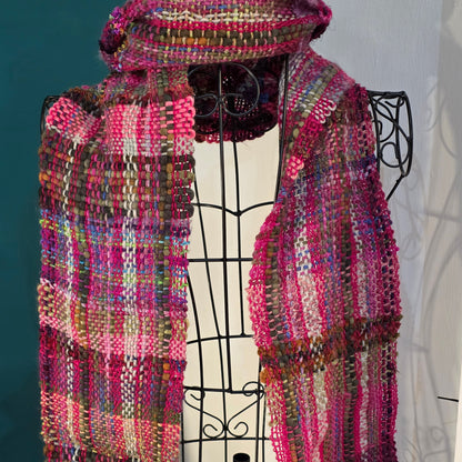 Multicolored woven scarf and hat on a decorative stand