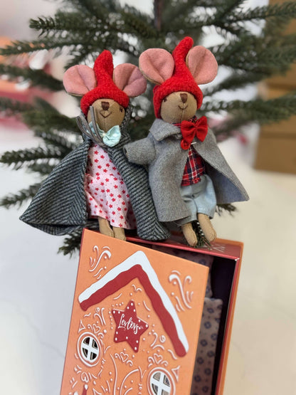Two toy mice in outfits with a decorative box on a tree branch background