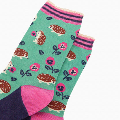 Colorful socks with hedgehog and flower pattern on a white background