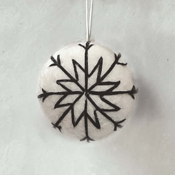 Round stone pendant with black snowflake design on a light gray background