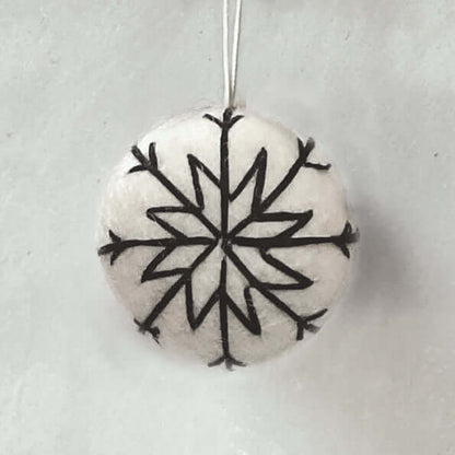 Round stone pendant with black snowflake design on a light gray background