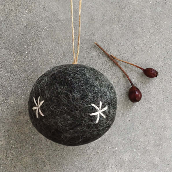 Black felt ornament with white star patterns on a gray surface