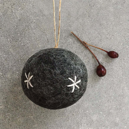 Black felt ornament with white star patterns on a gray surface