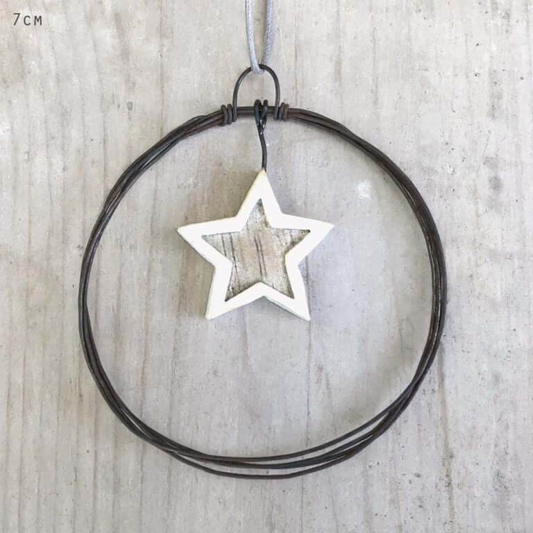 Star-shaped pendant on a wire against a wooden background