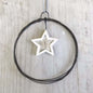 Star-shaped pendant on a wire against a wooden background