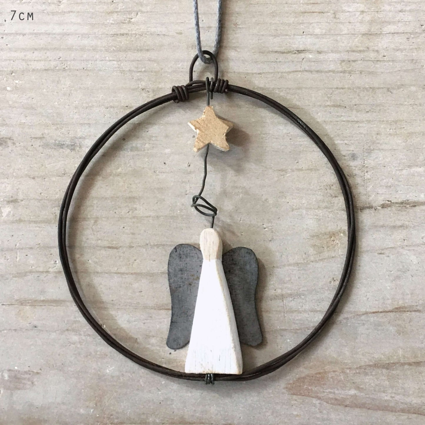 Decorative hanging with angel wings and a star on a neutral background