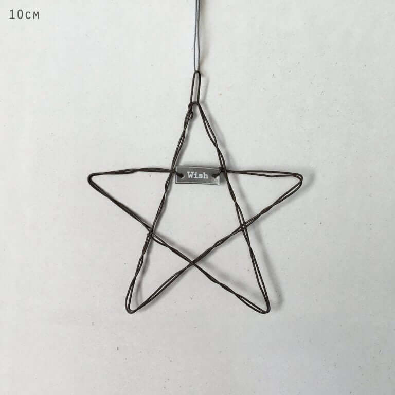Wire star ornament with 'Wish' tag on a light gray background