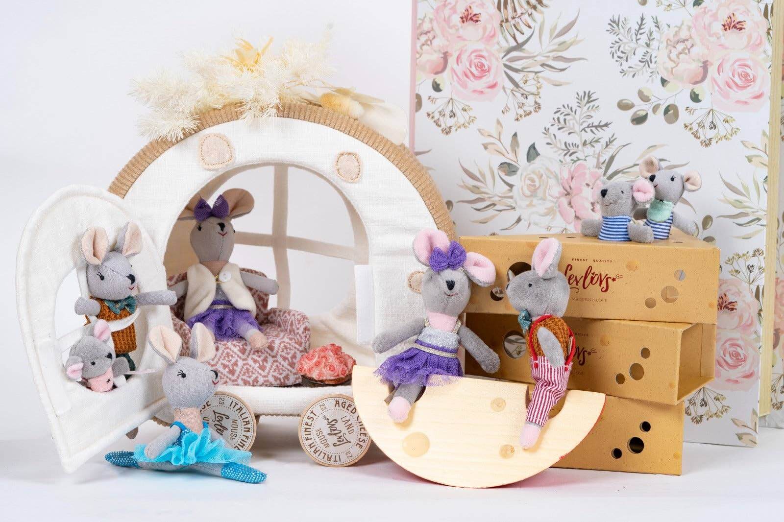 Collection of plush mouse toys with a decorative background featuring floral patterns.