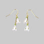 Pair of floral earrings with gold chains on a gray background