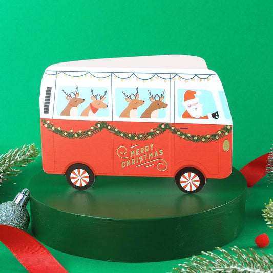 Red Christmas-themed van with reindeer and Santa on a green background