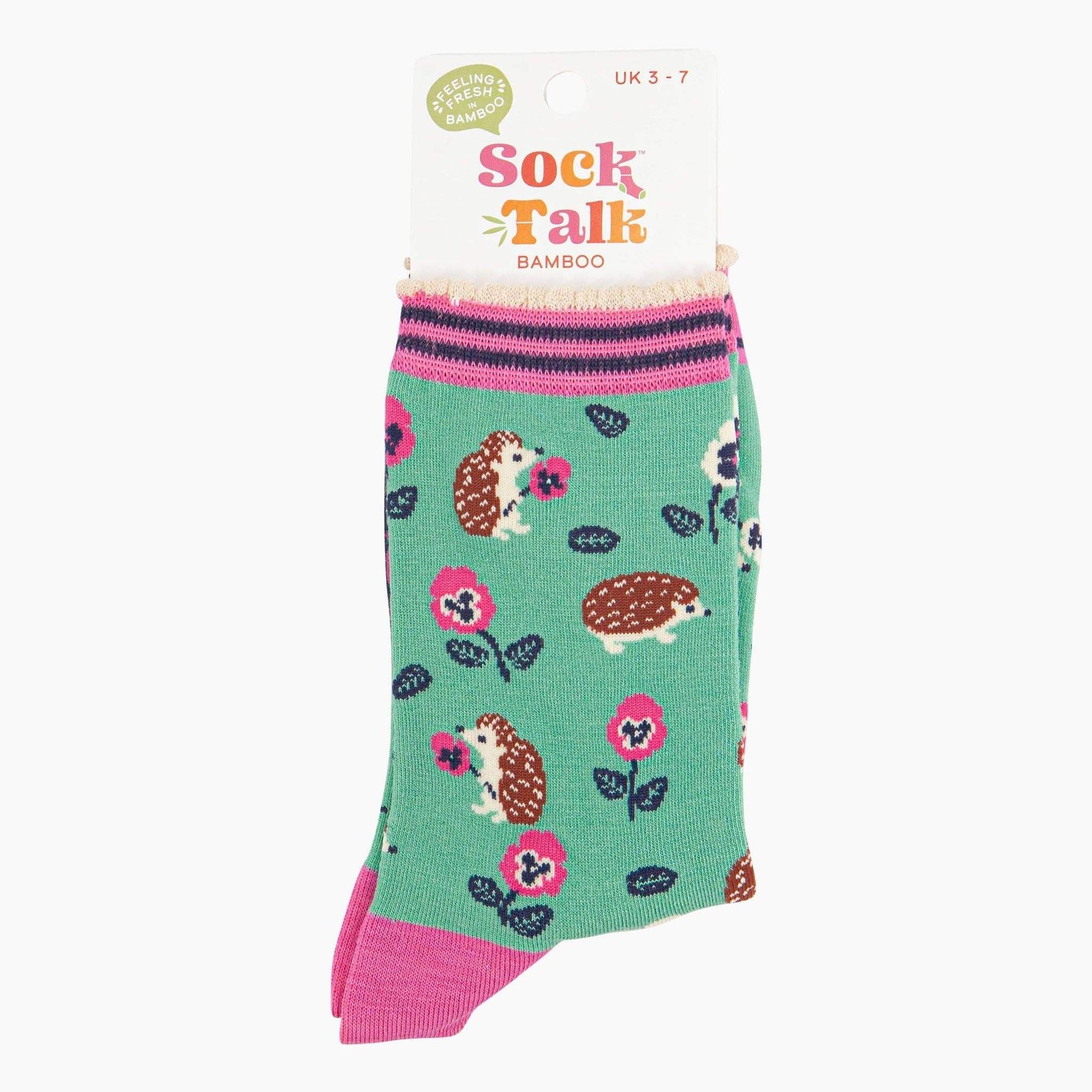 Green socks with hedgehog and flower pattern on a white background