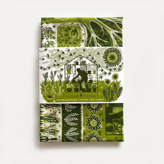 Green and white patterned tea towel with screenprinted design on a white background