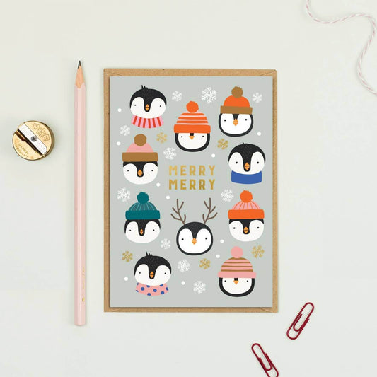 Framed artwork with penguins wearing winter hats on a light gray background