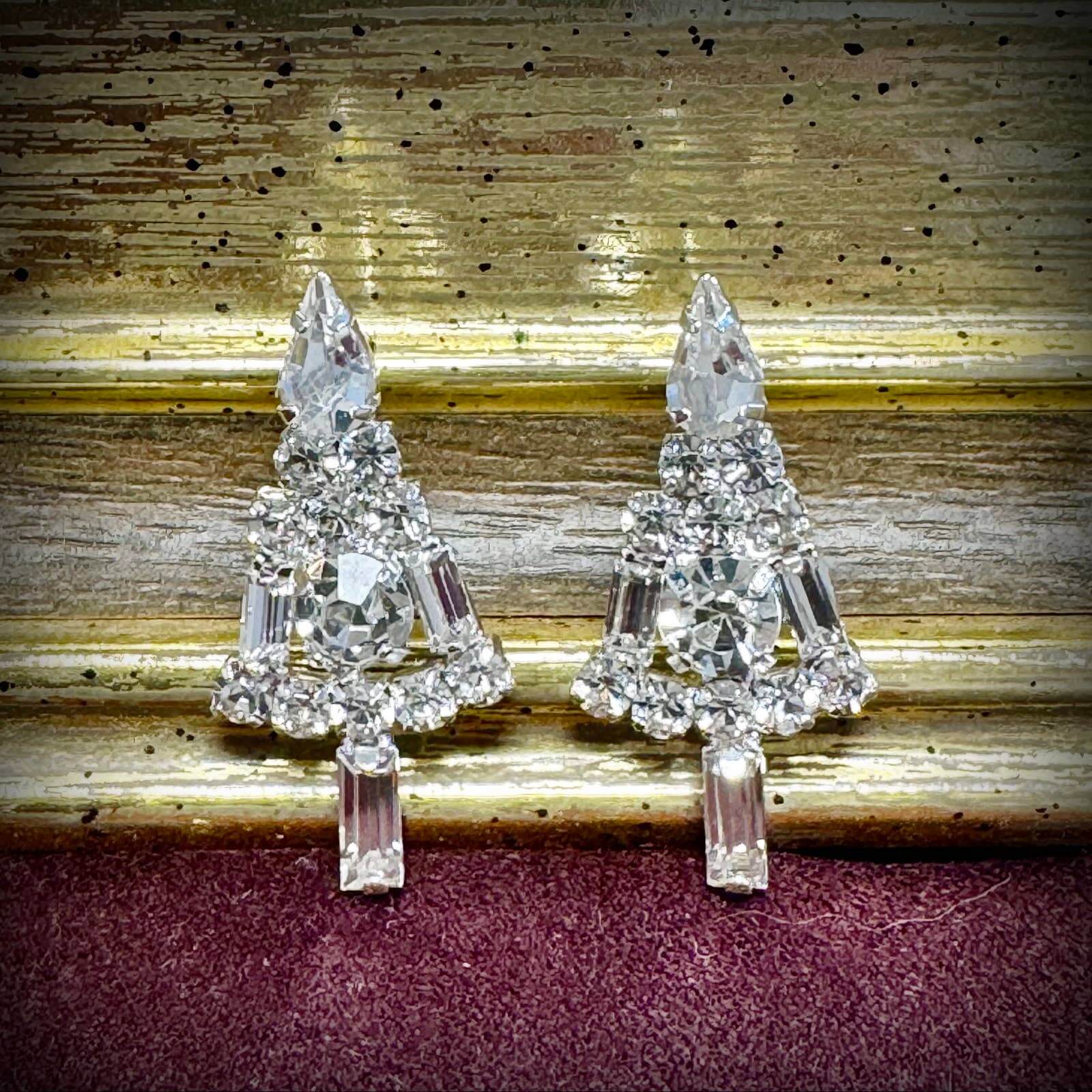 Pair of crystal tree-shaped earrings on a textured surface