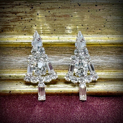 Pair of crystal tree-shaped earrings on a textured surface