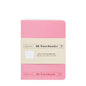 Pink A6 notebook with beige label on a white background