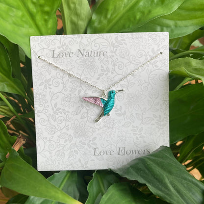 Hummingbird necklace on a 'Love Nature Love Flowers' card with green leaves in the background