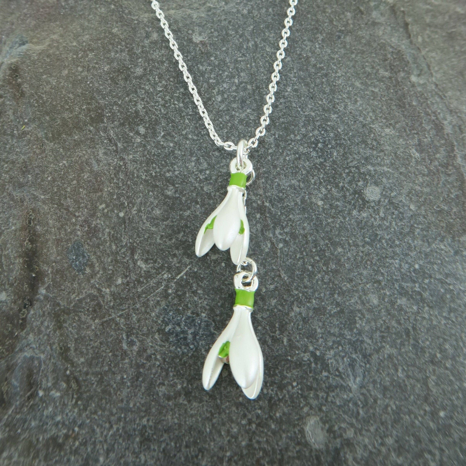 Floral pendant necklace on a chain against a stone background