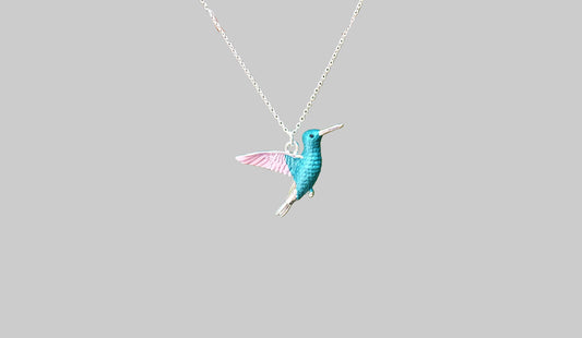 Teal hummingbird pendant on a silver chain against a light gray background