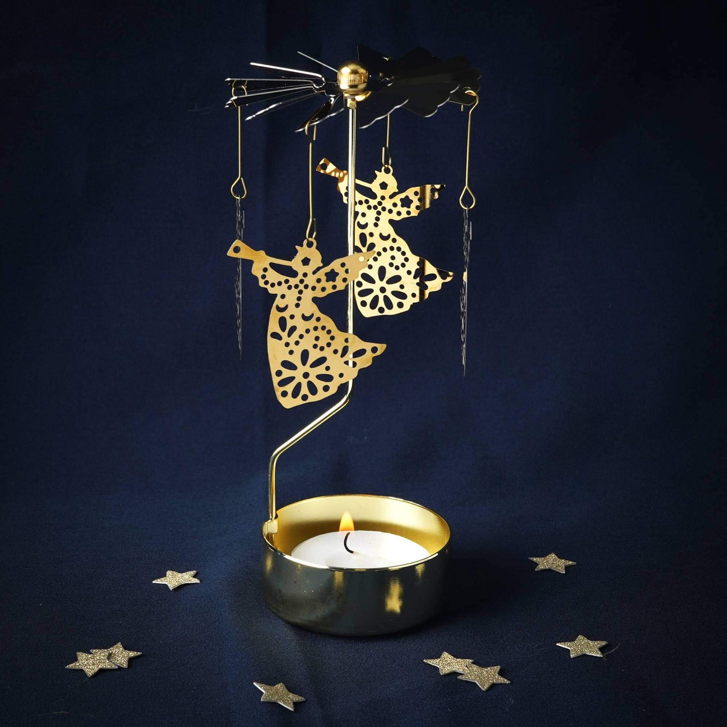 Decorative candle holder with gold marionette figures on a dark blue background