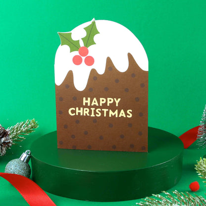 Christmas-themed card with a brown box, white icing, and holly leaves on a green background.