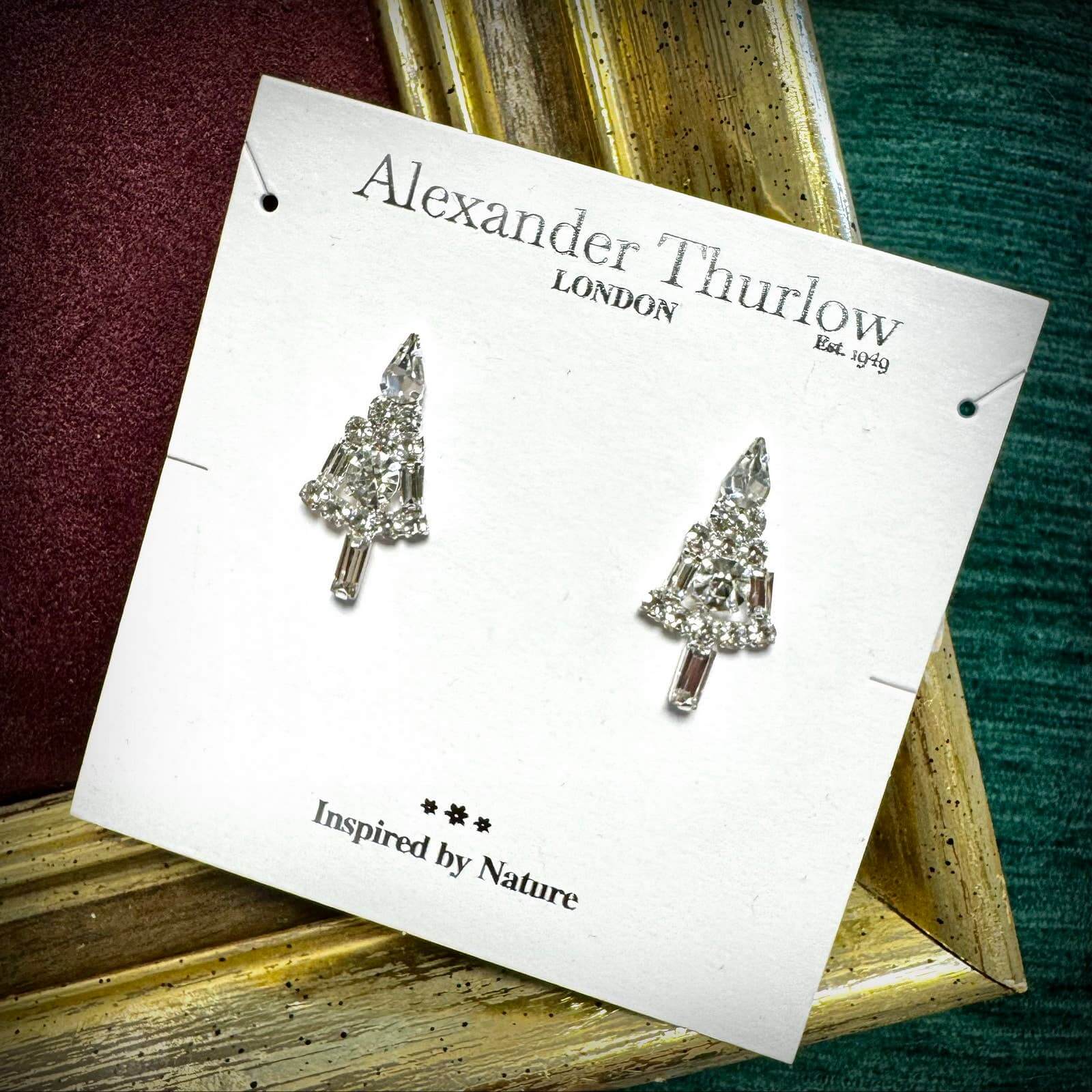 Tree-shaped earrings on a 'Alexander Thurlow London' card with a nature theme.