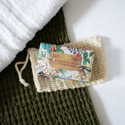 Bar of soap with floral packaging on a textured green surface