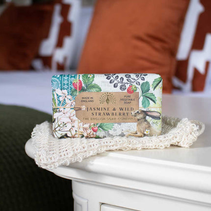 Soap bar with decorative packaging on a white surface with a blurred background