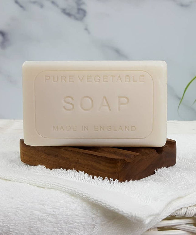 Bar of pure vegetable soap on a wooden stand with a marble background